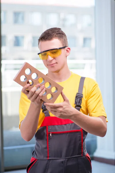 Jovem trabalhador da construção em macacões amarelos — Fotografia de Stock