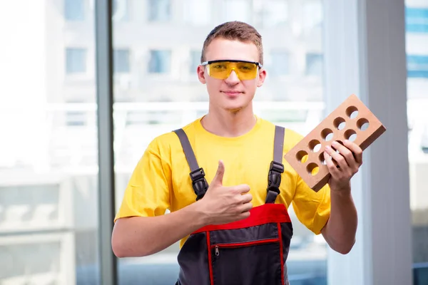 Молодой строитель в желтом комбинезоне — стоковое фото