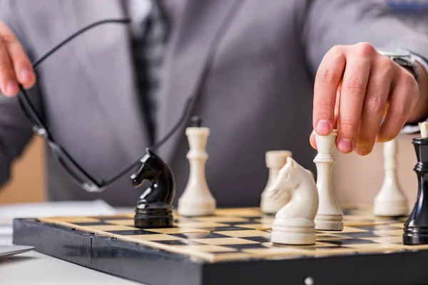 Jeune homme d'affaires jouant aux échecs dans le bureau — Photo