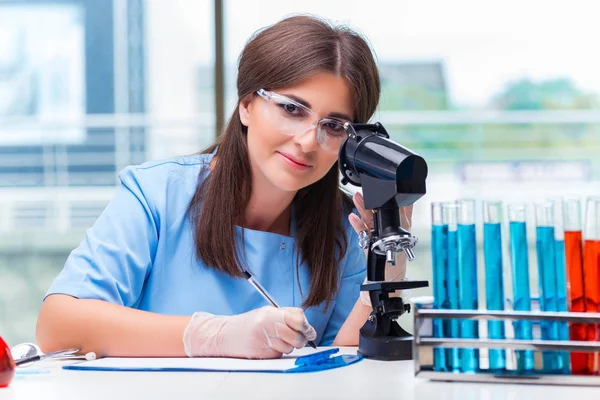 Giovane donna che lavora in laboratorio — Foto Stock