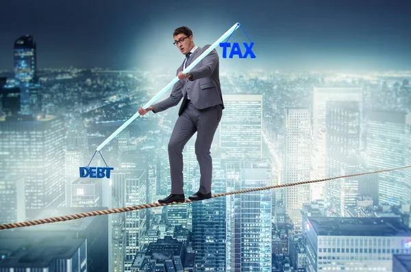 Businessman balancing between debt and tax — Stock Photo, Image