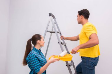 Evde duvar boyayan genç bir çift.