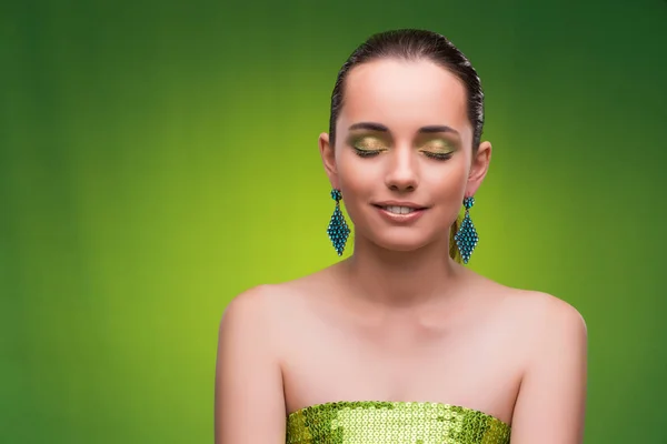 Молода жінка в концепції краси на зеленому фоні — стокове фото