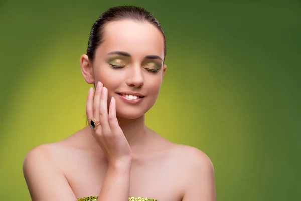 Jovem mulher no conceito de beleza no fundo verde — Fotografia de Stock