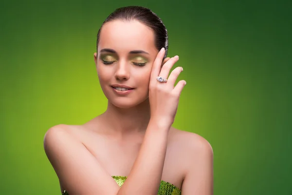 Jovem mulher no conceito de beleza no fundo verde — Fotografia de Stock