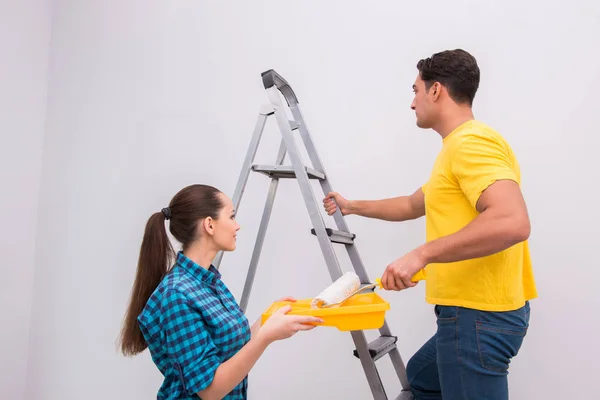 Jovem casal parede de pintura em casa — Fotografia de Stock