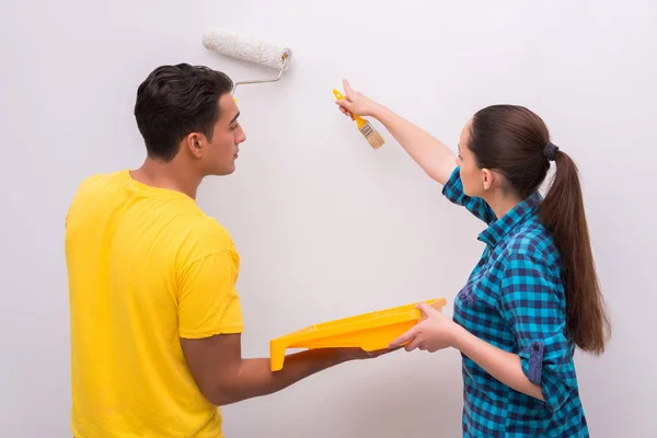 Jovem casal parede de pintura em casa — Fotografia de Stock