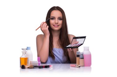 Beyazlar içinde makyaj yapan kadın.