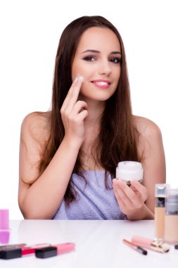 Beyazlar içinde makyaj yapan kadın.