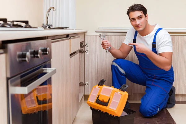 Junger Reparateur arbeitet in der Küche — Stockfoto