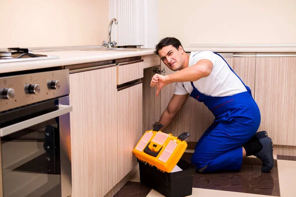 Ung reparatör som arbetar i köket — Stockfoto