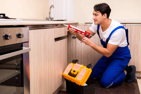 Junger Reparateur arbeitet in der Küche — Stockfoto