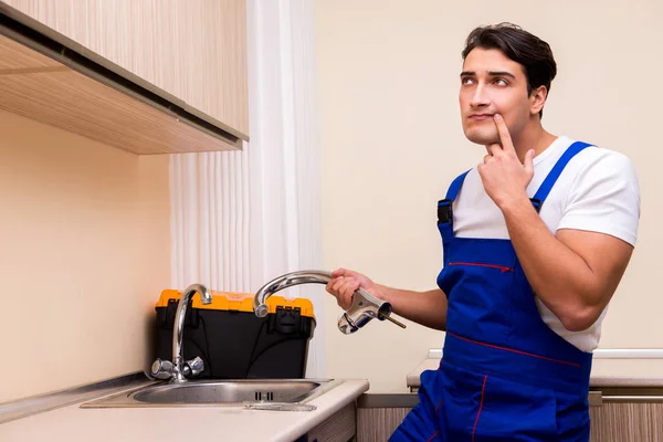 Young repairman working at the kitchen — Stock Photo, Image