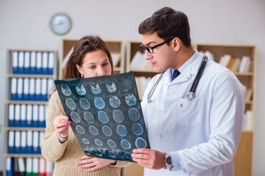 Genç doktor bilgisayardaki röntgen görüntülerine bakıyor.