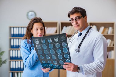 Genç doktor bilgisayardaki röntgen görüntülerine bakıyor.