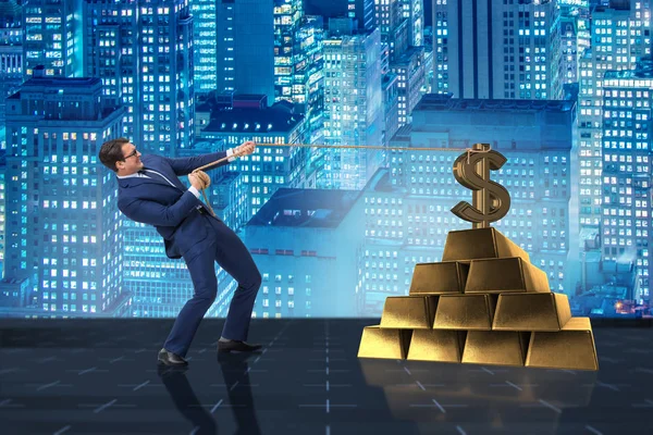 Бизнесмен тянет доллары и золотые слитки — стоковое фото