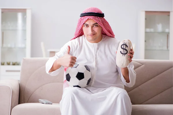 Hombre árabe joven viendo fútbol sentado en el sofá — Foto de Stock