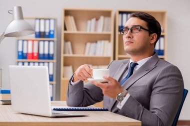 Genç yakışıklı işadamı ofiste çalışıyor.