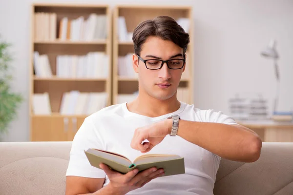 Hombre leyendo libro sentado en sofá sofá —  Fotos de Stock