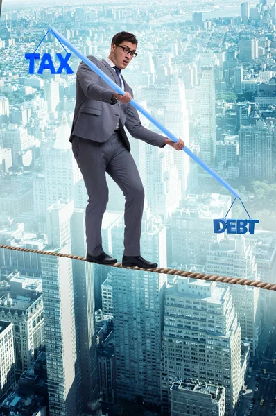 Businessman balancing between debt and tax