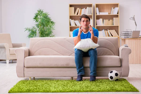 Hombre viendo fútbol en casa sentado en el sofá — Foto de Stock
