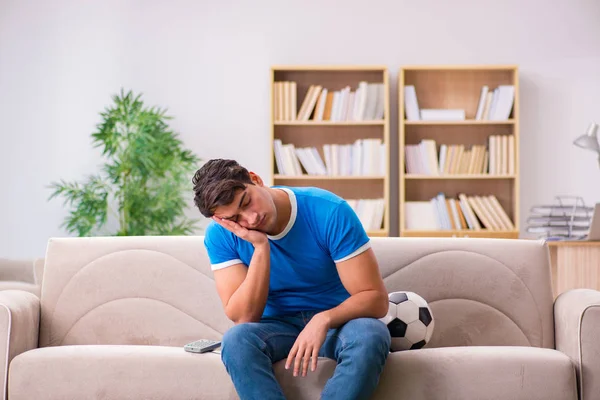 Hombre viendo fútbol en casa sentado en el sofá — Foto de Stock