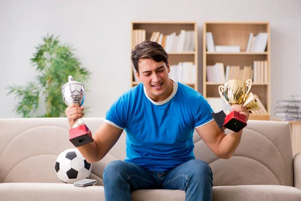 Чоловік дивиться футбол вдома, сидячи в дивані — стокове фото