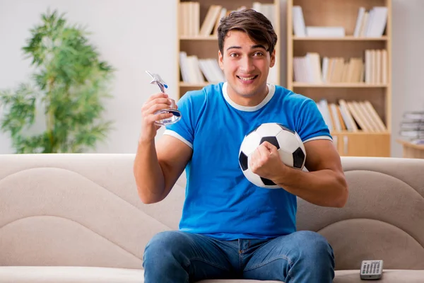 Man watching football at home sitting in couch — Stock Photo, Image