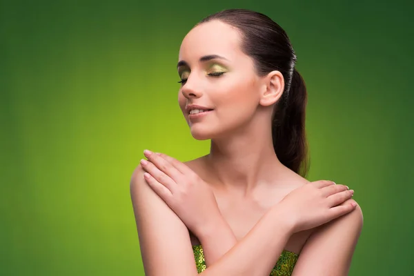 Mujer joven en concepto de belleza sobre fondo verde — Foto de Stock