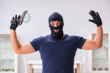 Soyguncu kar maskesi takıp değerli şeyler çalıyor.