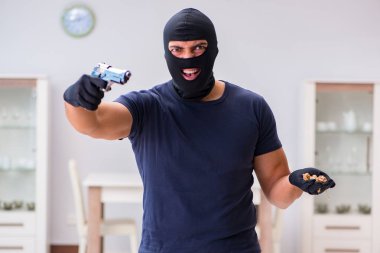 Soyguncu kar maskesi takıp değerli şeyler çalıyor.