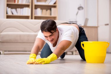 Koca adam evi temizliyor, karısına yardım ediyor.