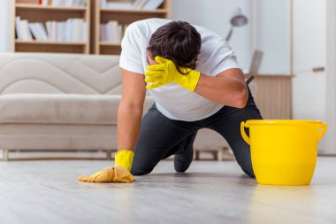 Koca adam evi temizliyor, karısına yardım ediyor.