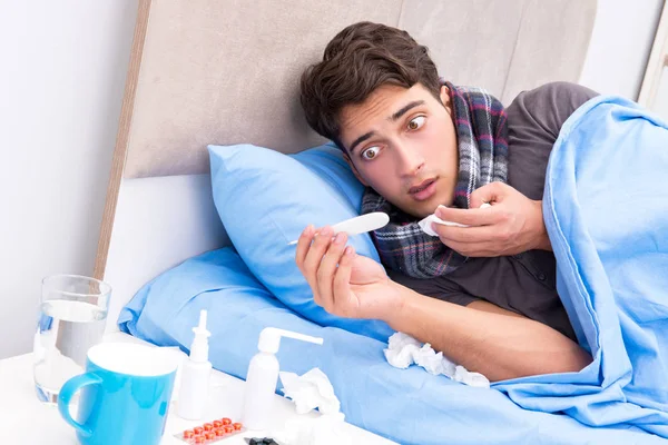 Nemocný muž s chřipkou ležící v posteli — Stock fotografie
