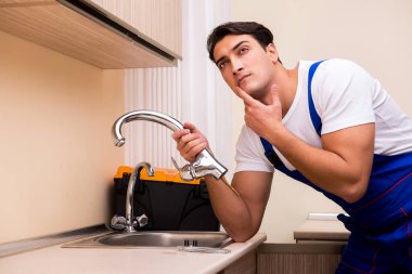 Mutfakta çalışan genç tamirci.