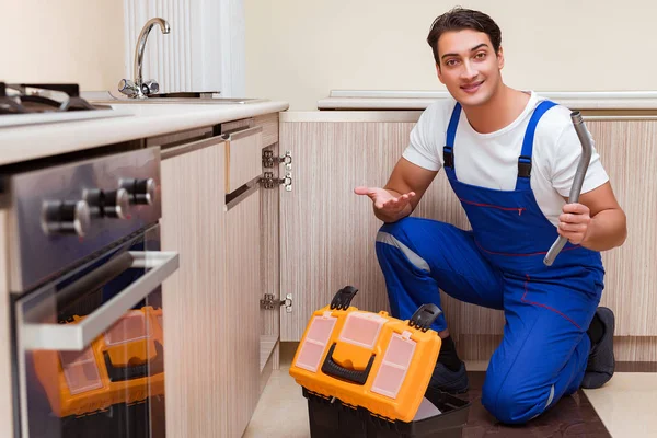 Jonge reparateur werkt in de keuken — Stockfoto