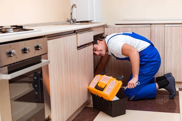Jonge reparateur werkt in de keuken — Stockfoto