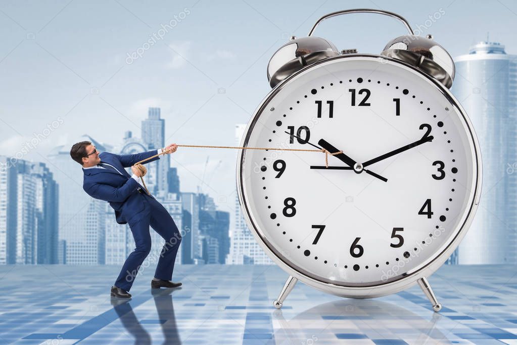 Businessman pulling clock in time management concept