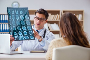 Genç doktor bilgisayardaki röntgen görüntülerine bakıyor.