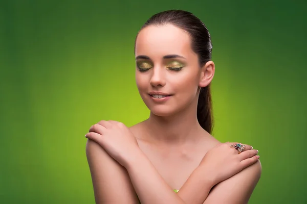 Jovem mulher no conceito de beleza no fundo verde — Fotografia de Stock