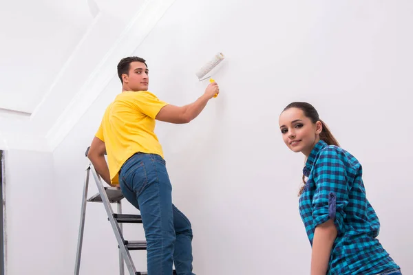 Fiatal pár festészet fal otthon — Stock Fotó