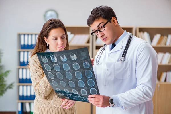 Genç doktor bilgisayardaki röntgen görüntülerine bakıyor.