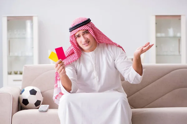 Hombre árabe joven viendo fútbol sentado en el sofá — Foto de Stock