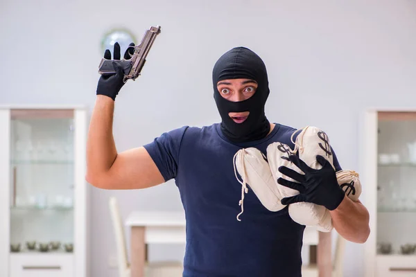 Ladrão usando balaclava roubando coisas valiosas — Fotografia de Stock