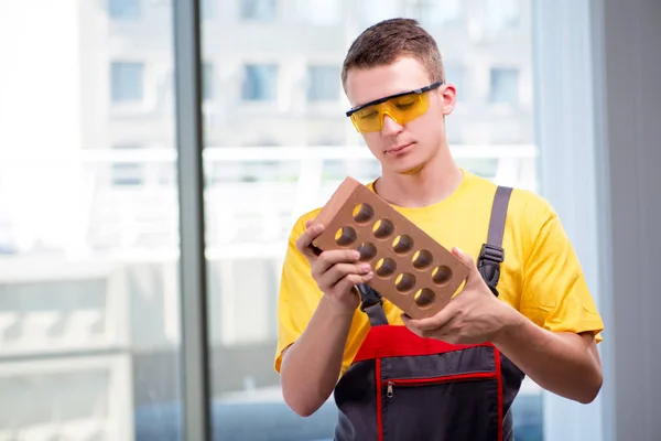 Jovem trabalhador da construção em macacões amarelos — Fotografia de Stock