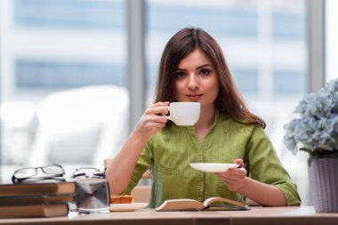 Sınavlara hazırlanan genç öğrenci çay içiyor.