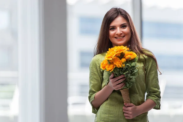 Ung flicka med present av blommor — Stockfoto