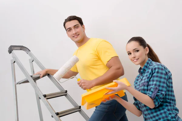 Jovem casal parede de pintura em casa — Fotografia de Stock