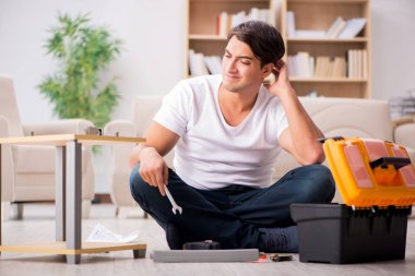 Evdeki rafları monte eden adam