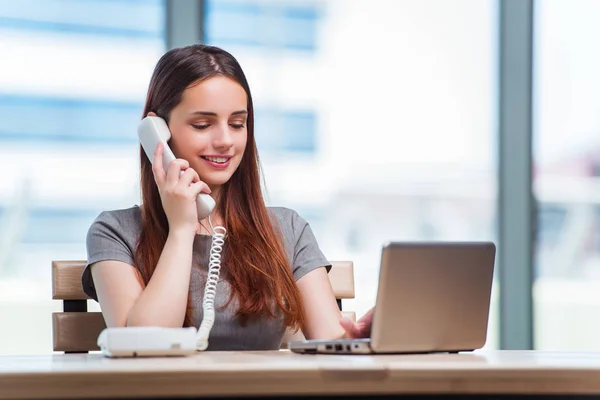 Jonge vrouw in gesprek over de telefoon in het kantoor — Stockfoto